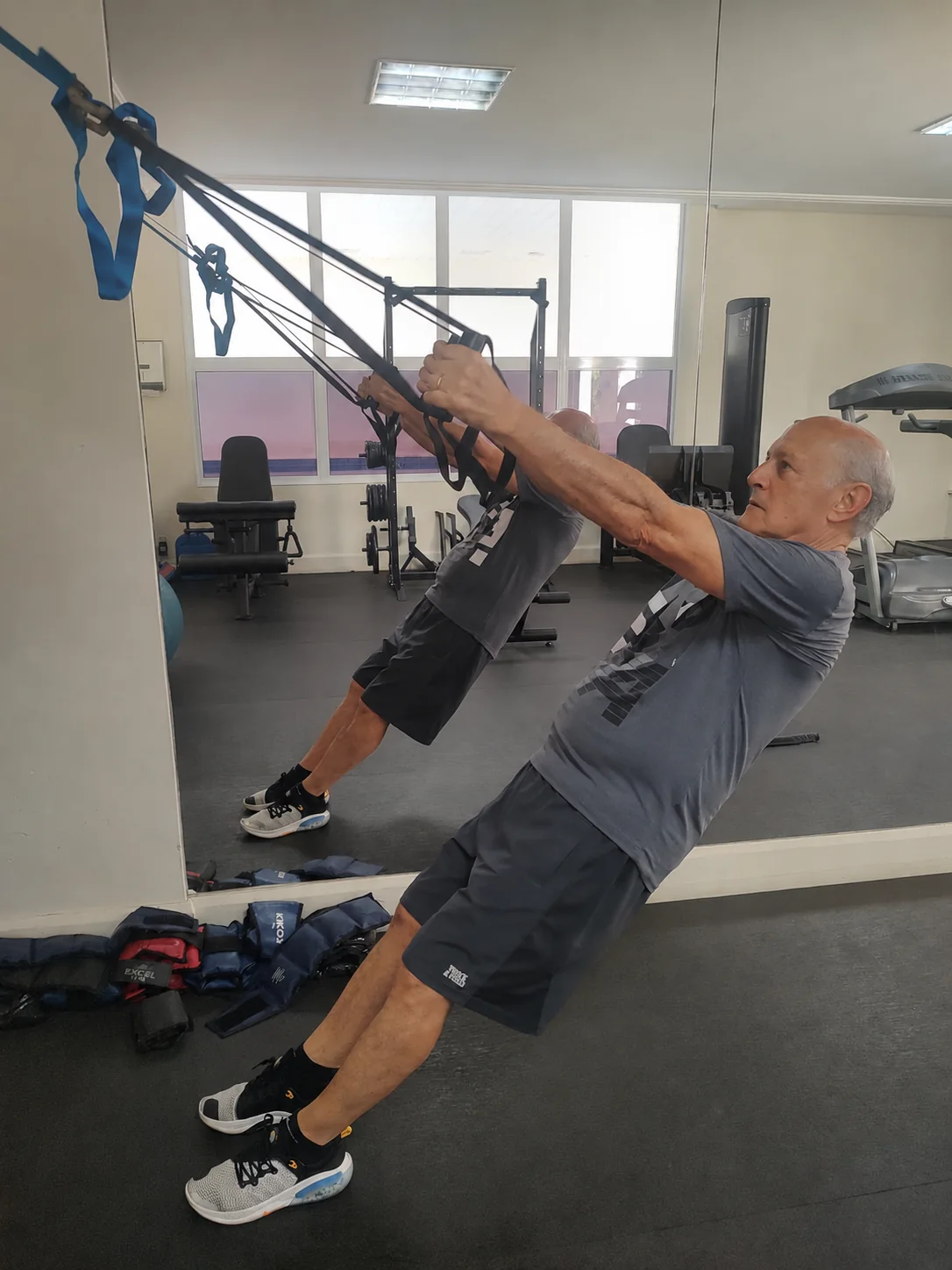 Homem idoso realizando exercício com faixas