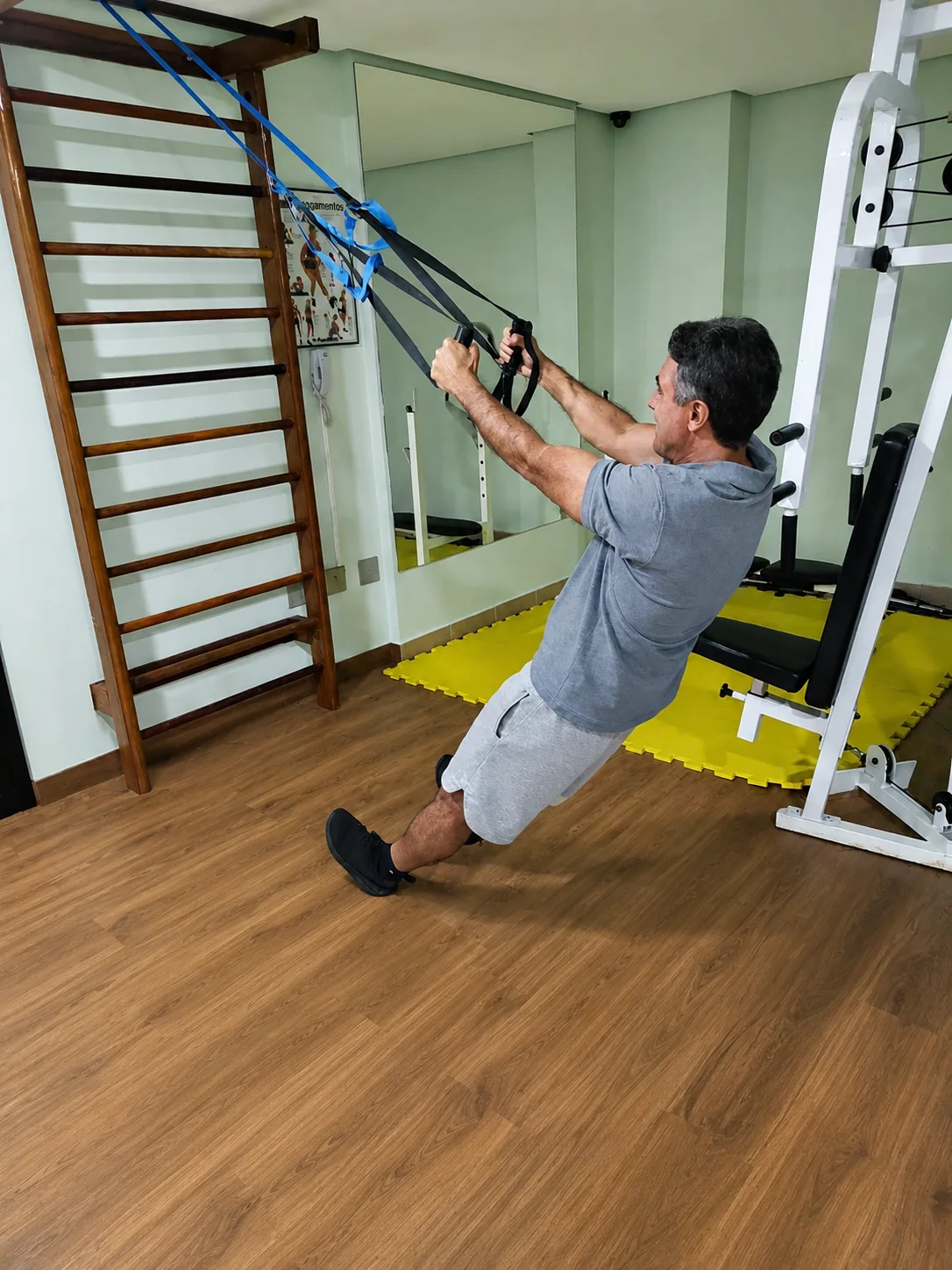 Homem adulto realizando exercício com faixas